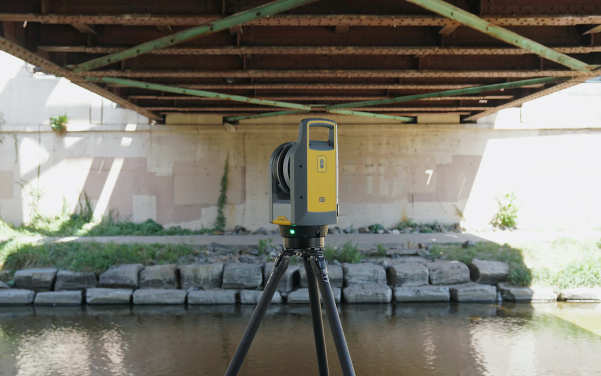 Skaner laserowy 3D na statywie pod stalową konstrukcją mostu
